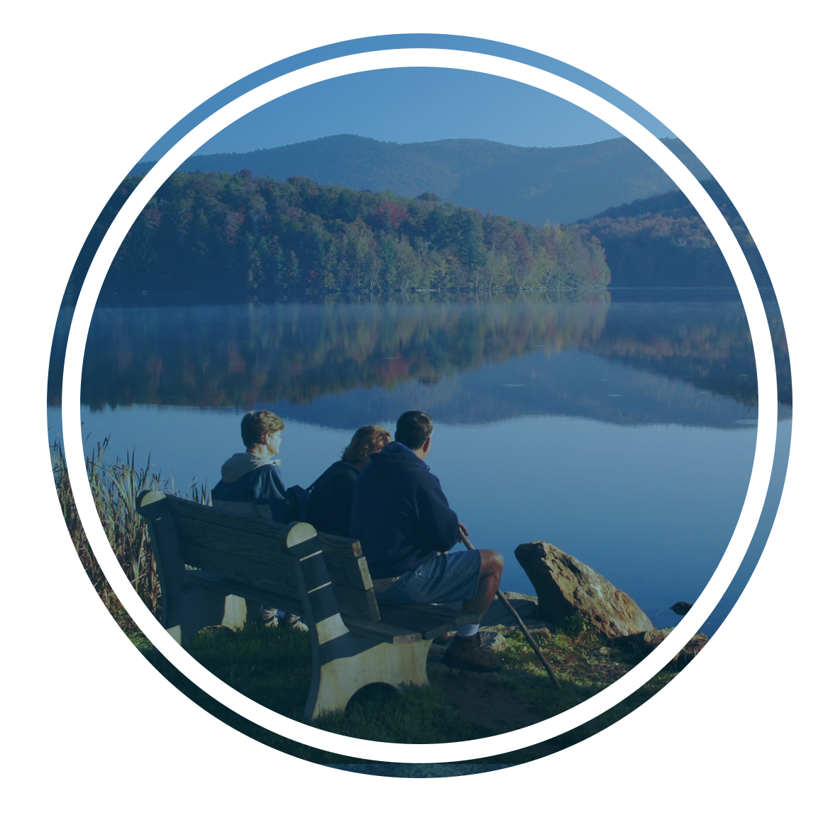 family sitting on bench overlooking lake