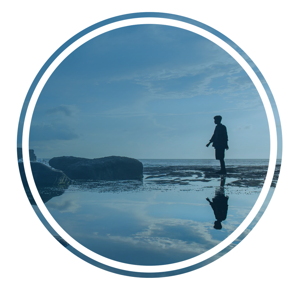 woman looking at rocks on beach