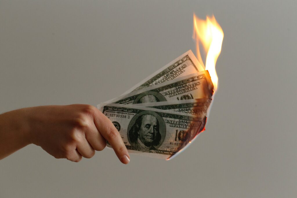 person lighting 4 100 dollar bills on fire